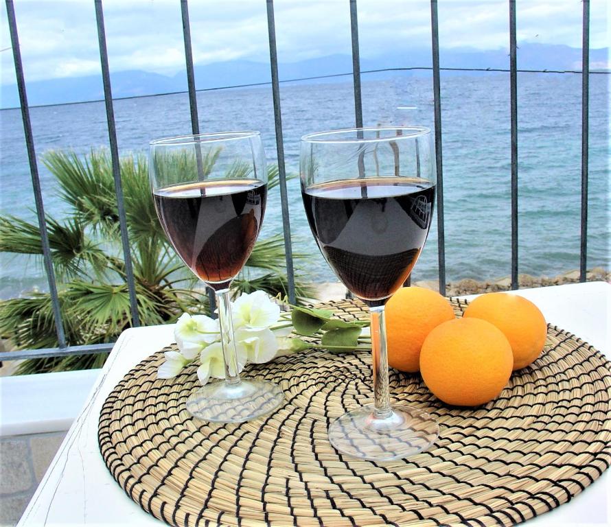 阿克拉塔Galini Studios Paralia Platanou的两杯酒坐在桌子上,配橙子