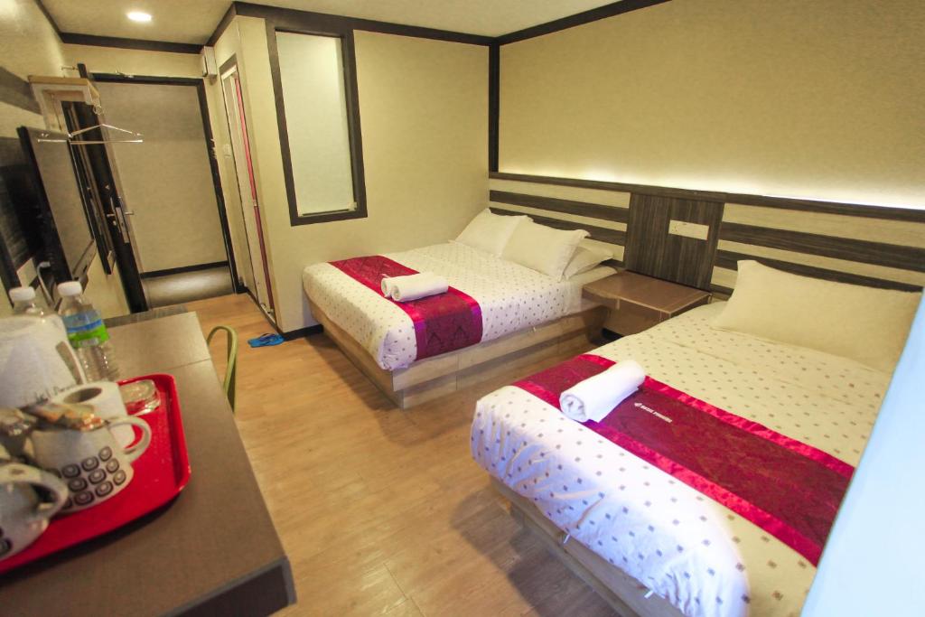 怡保HOTEL PREMIUM的酒店客房设有两张床和一张桌子。