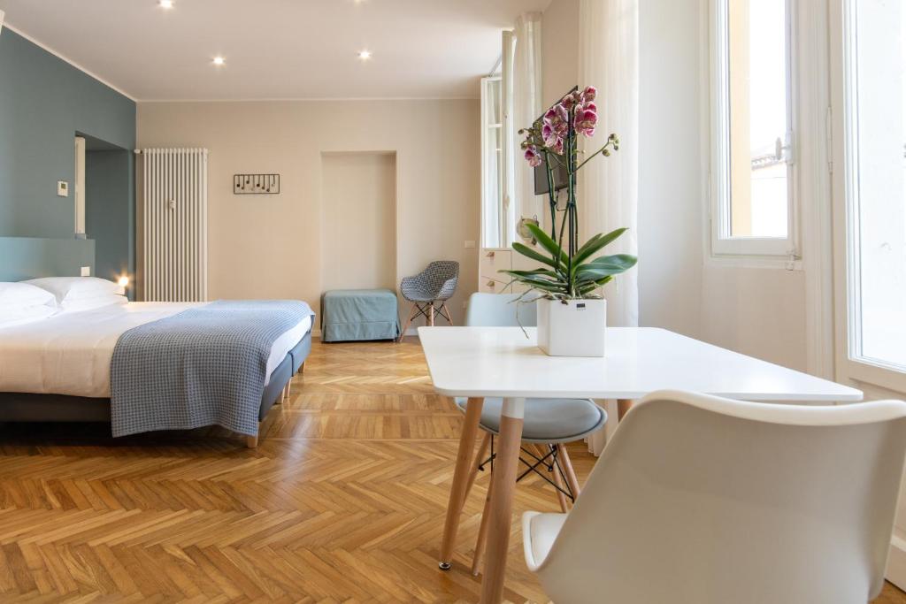 韦尔巴尼亚Aqualago casa vacanze - apartament B的酒店客房带一张床、一张桌子和椅子