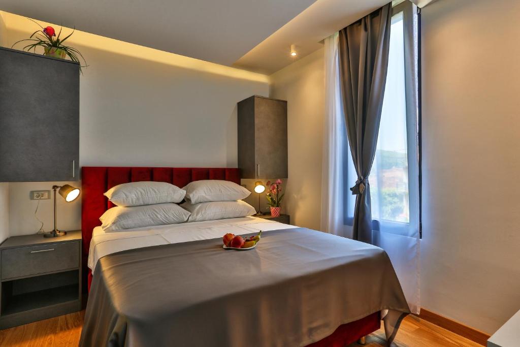 波德戈里察M酒店的一间卧室设有一张大床和一个窗户。