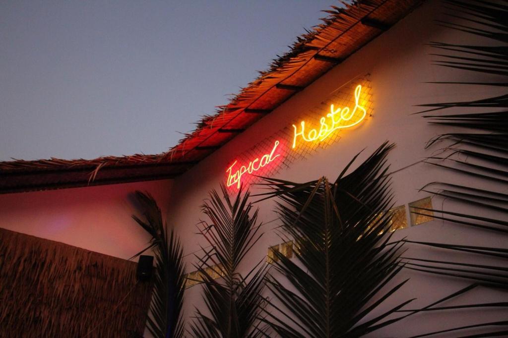 阁帕延岛Tropical Hostel的建筑物一侧的 ⁇ 虹灯标志