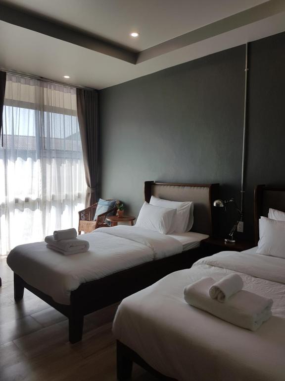 南府Mon-Dee minihotel的酒店客房设有两张床和窗户。