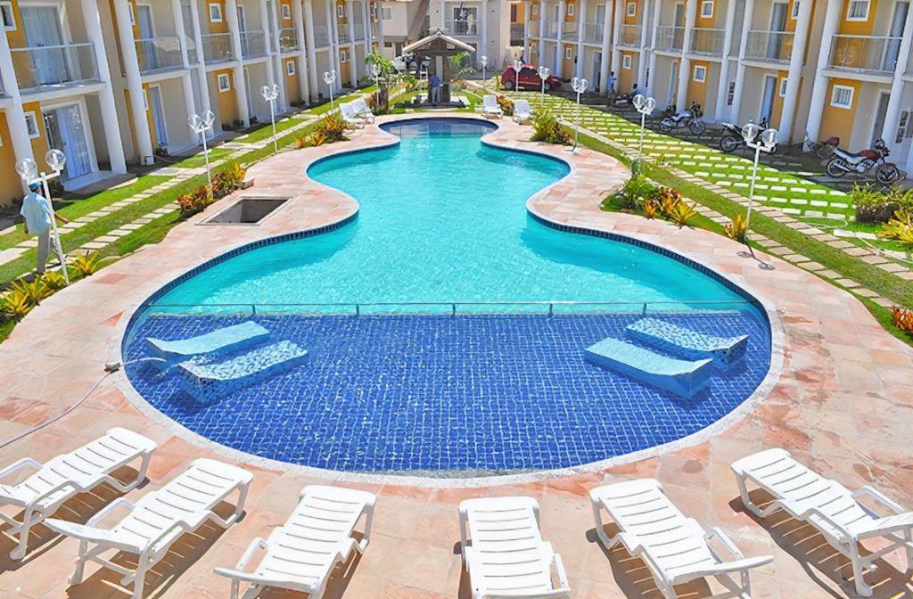 塞古罗港FLAT RESID MONT CARMELO的一个带躺椅的游泳池和一间酒店