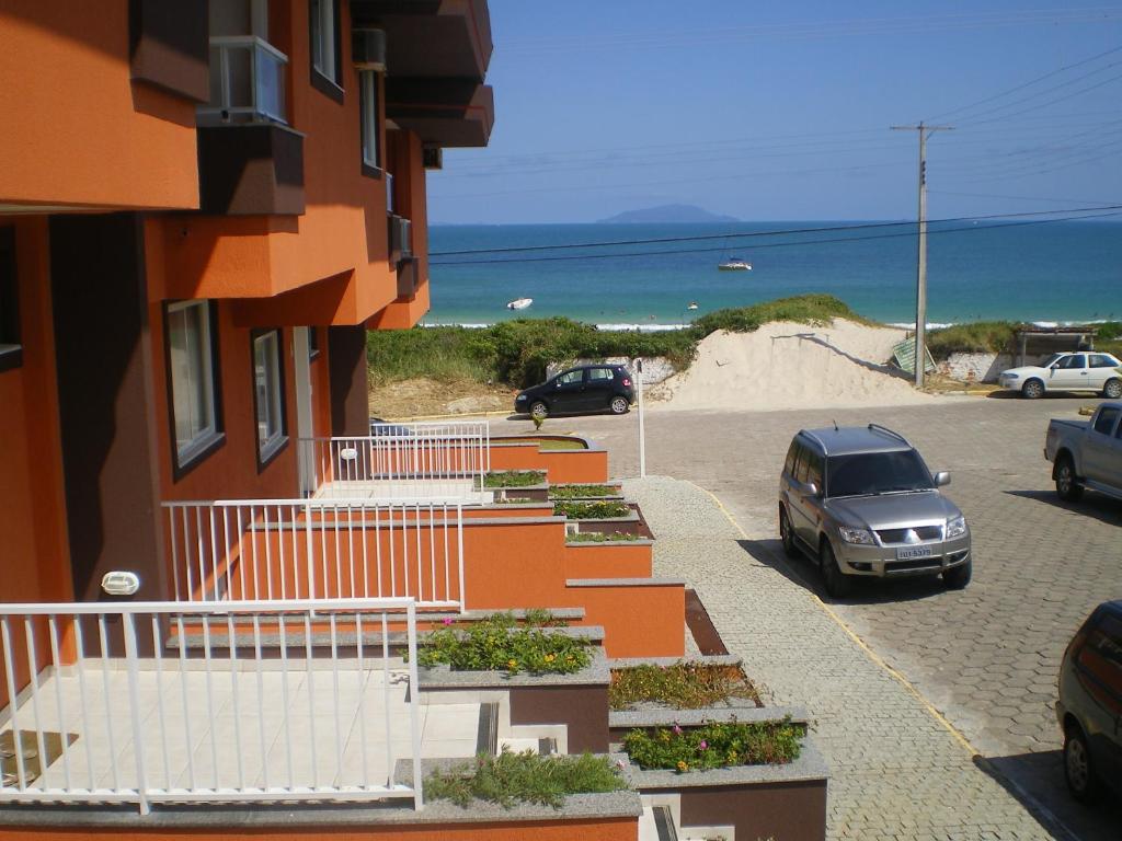 邦比尼亚斯Praia de Quatro Ilhas a 50 metros do mar的海滩旁停车场的停车位