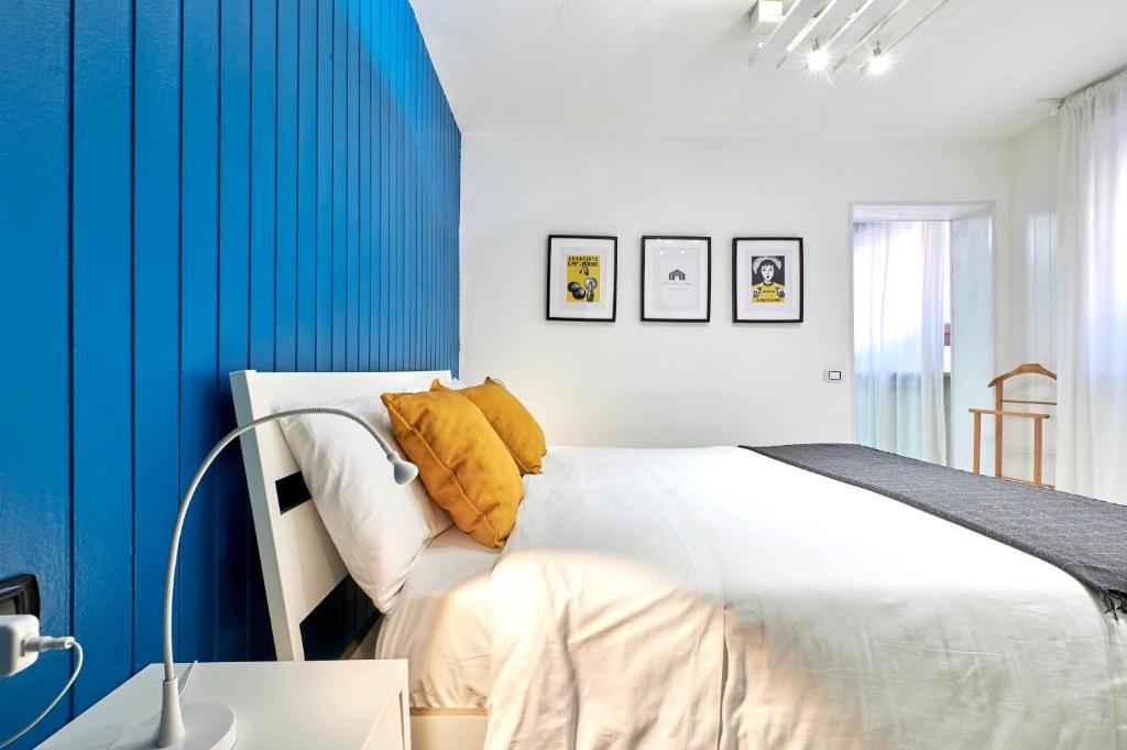 圣佩莱格里诺温泉Design Suite Cavagna的卧室配有白色的床和蓝色的墙壁