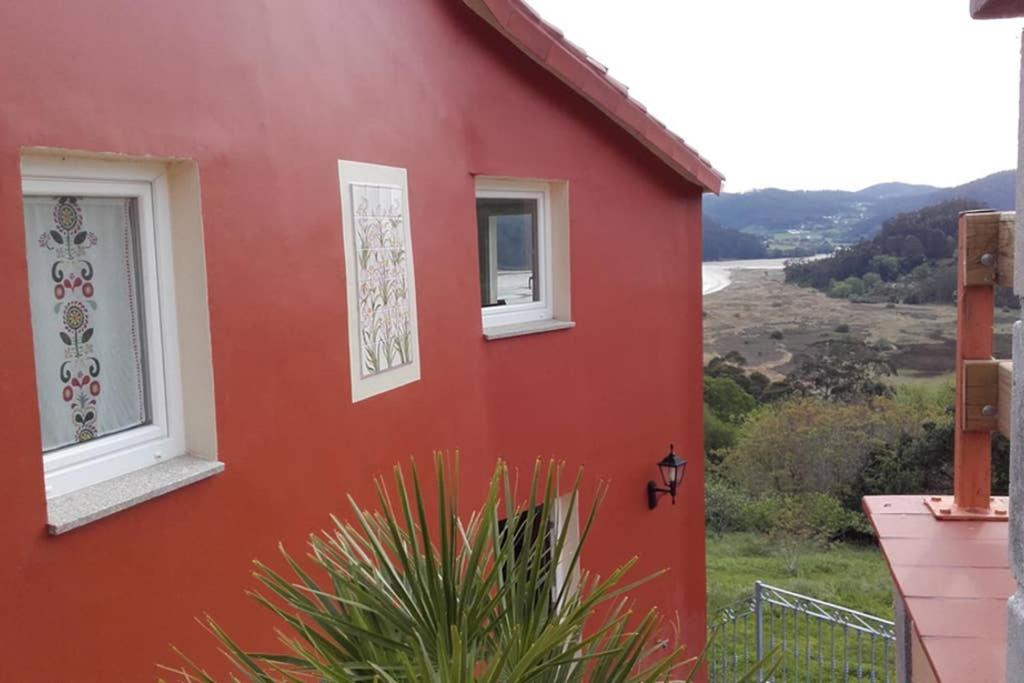 巴尔多维尼奥Casa acogedora con vistas al mar的两扇窗户的红色房子