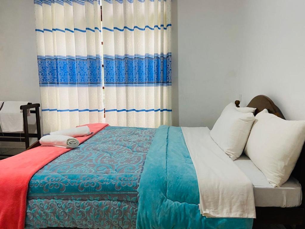 努沃勒埃利耶Shiny View的一间卧室配有一张带蓝白色毯子的床