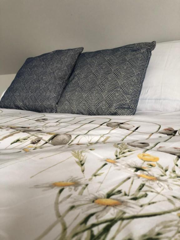 登德尔蒙德Molenstraat的一张带两个枕头的床,床上有鲜花