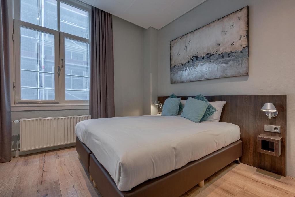 阿姆斯特丹Hotel Damsquare的一间卧室设有一张床和一个大窗户