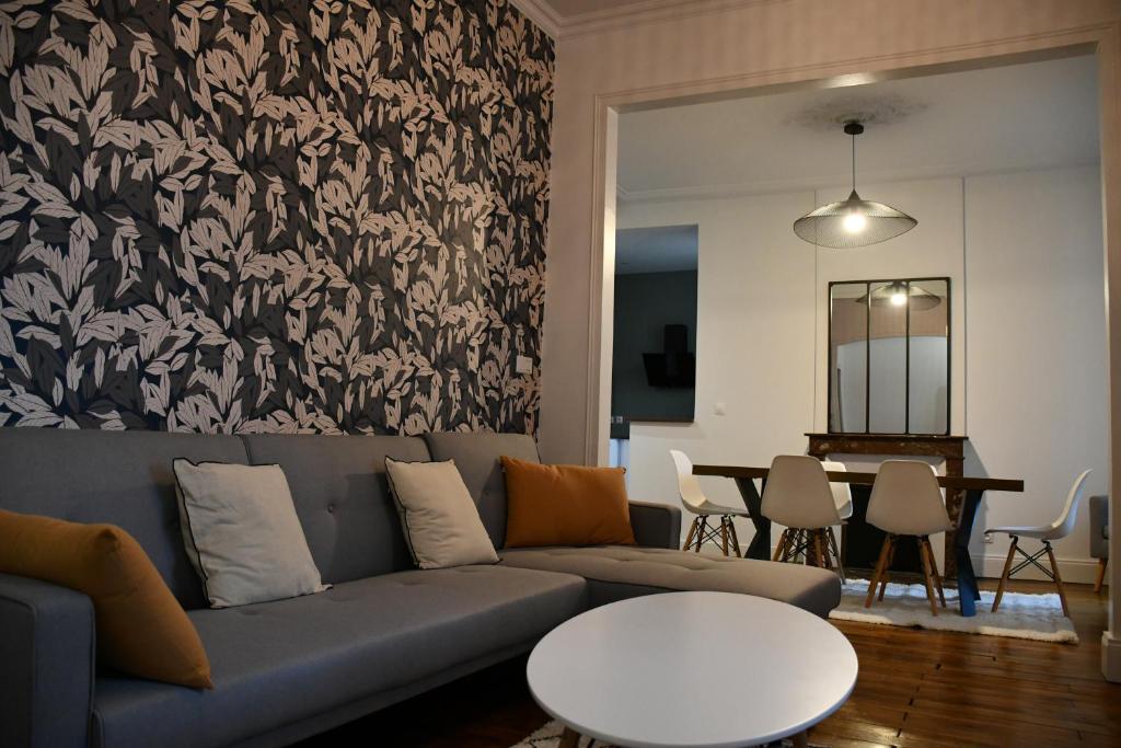 里摩日Maison bourgeoise Haussmannienne - Gîtes de France的客厅配有沙发和桌子