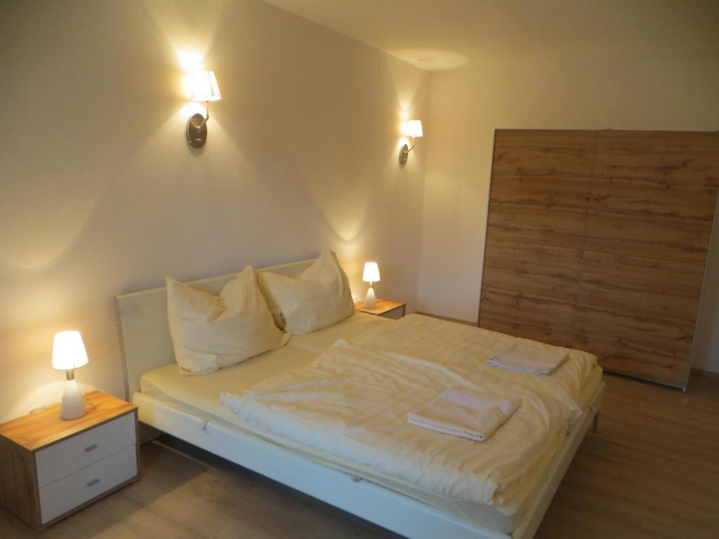 萨尔茨堡City Apartment Amadeus的一间卧室配有一张带2个床头柜和2盏灯的床。