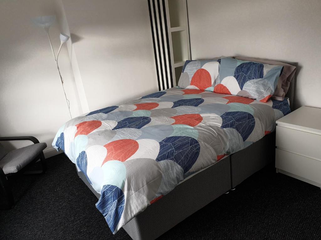 贝尔法斯特Private Room on Donegall Road in Central Belfast的一间卧室配有一张带五颜六色被子的床