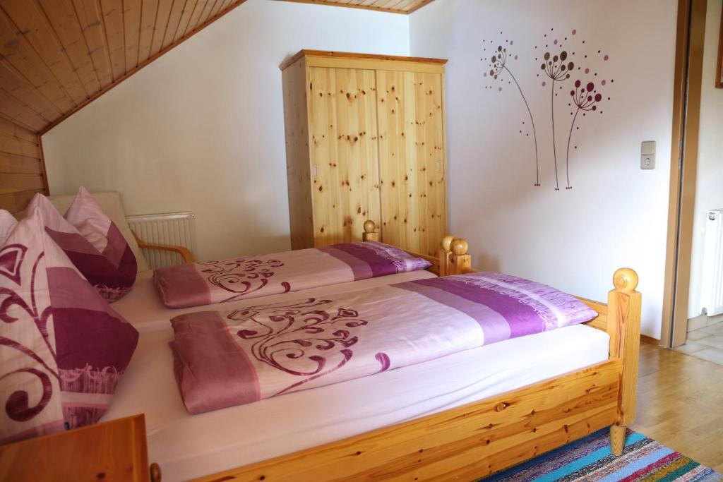 ArriachLandhaus Unterköfler的一间卧室配有一张大床和木制床头板