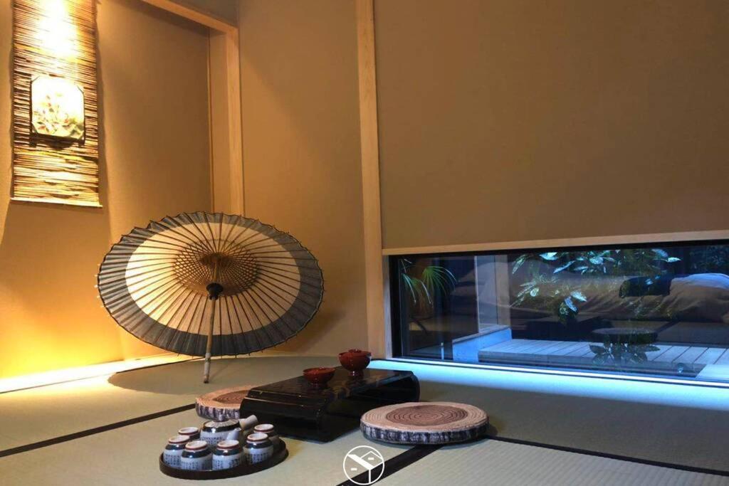 京都Minami的配有电视和桌子上的风扇的房间