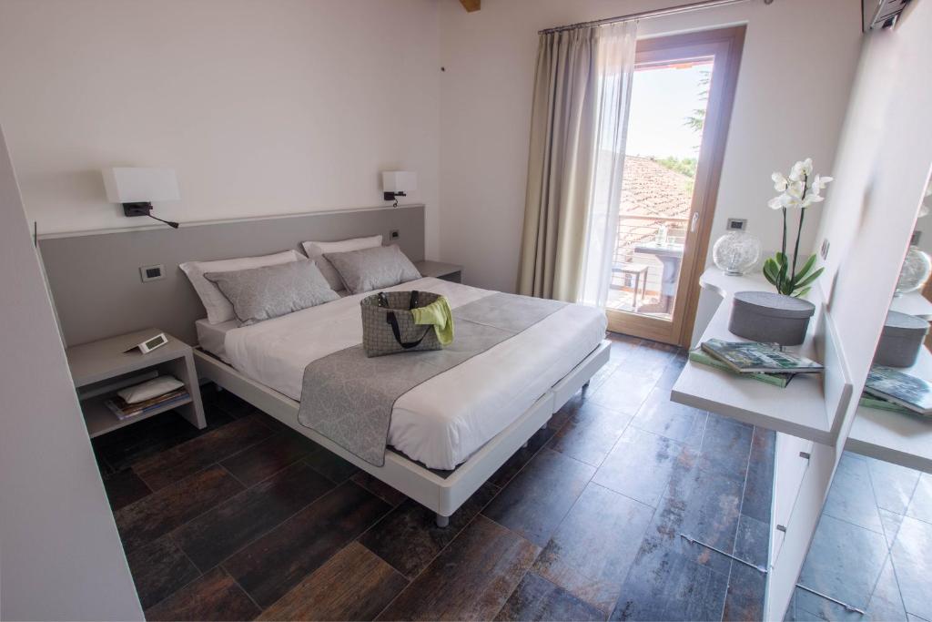 MartignaccoCasanova Inn的白色的卧室设有床和窗户