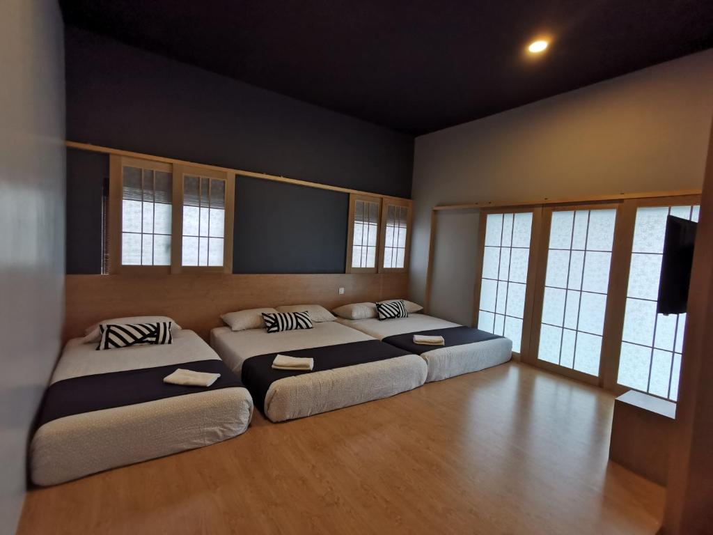 邦咯Tatami D'Tepi Laut - PANGKOR ISLAND的一间卧室配有两张床和一台平面电视