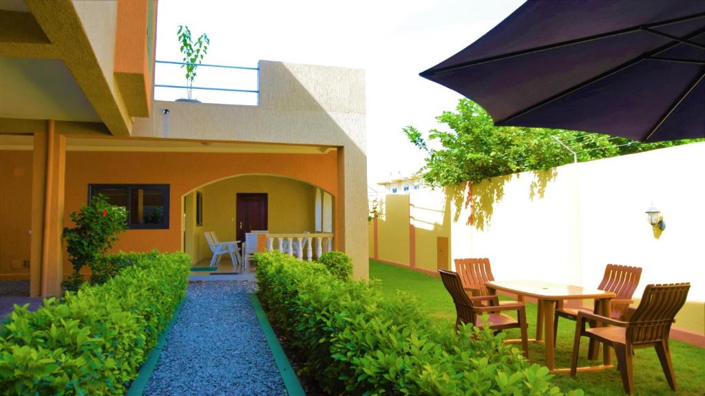 洛美Villa Beach Avepozo Lome的庭院配有桌椅和遮阳伞。
