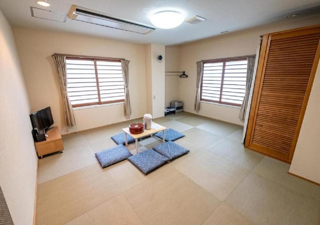阿扎格瓦kawagutiko station inn / Vacation STAY 63735的客厅的地板上设有蓝色垫子