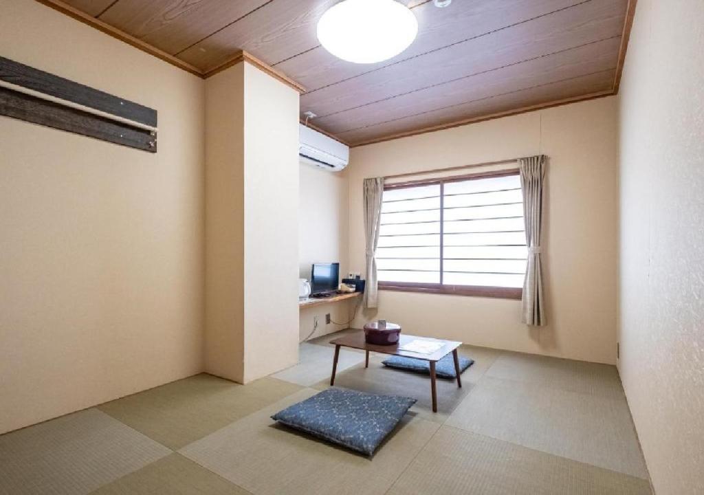 阿扎格瓦kawagutiko station inn / Vacation STAY 63732的客厅配有桌子和窗户