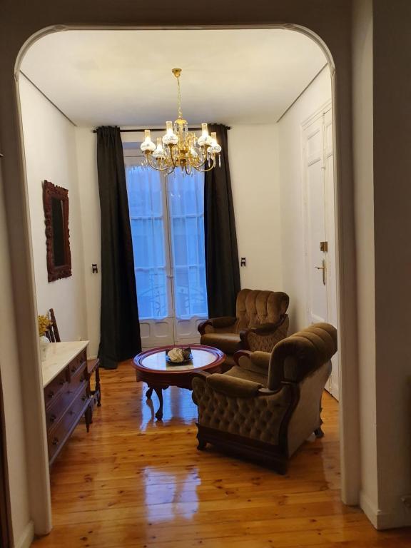 巴利亚多利德Casa burguesa de 1900的客厅配有两把椅子和一张桌子