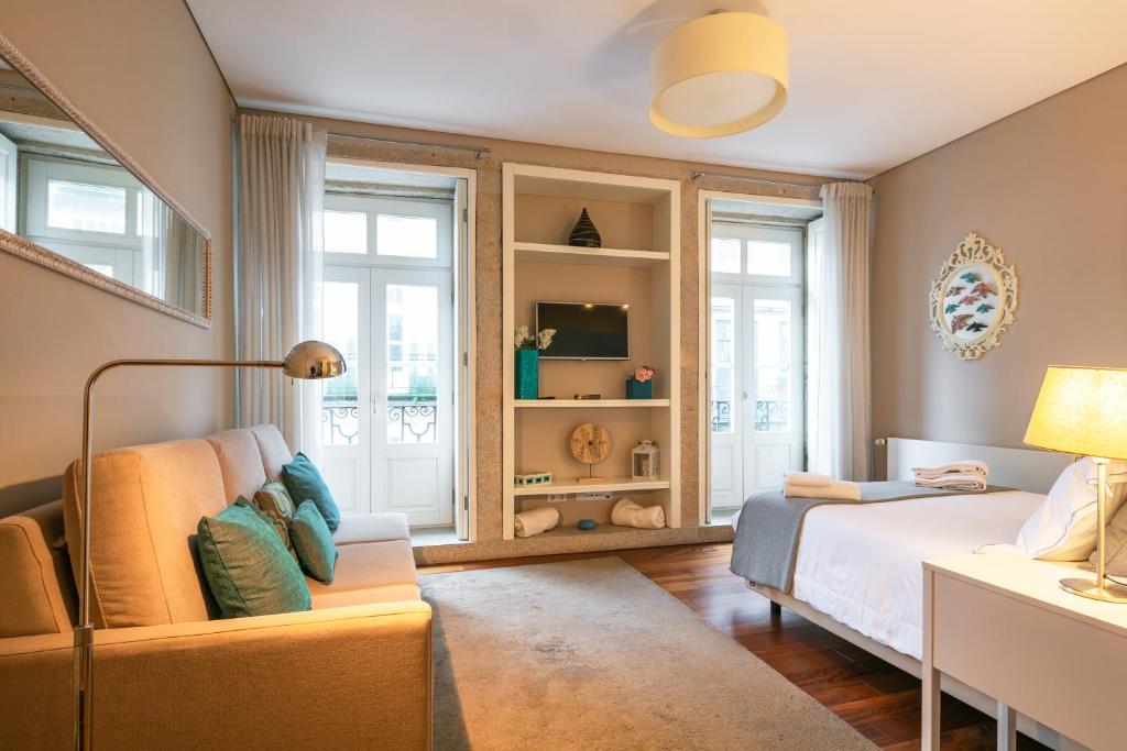 波尔图Cardosas Charming Apartment with Balconies的一间卧室配有一张床和一张沙发