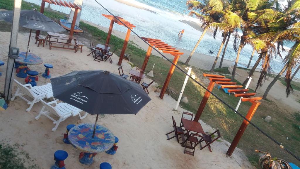 贝贝里比Pousada Recanto das Fontes的海滩上方的椅子和遮阳伞