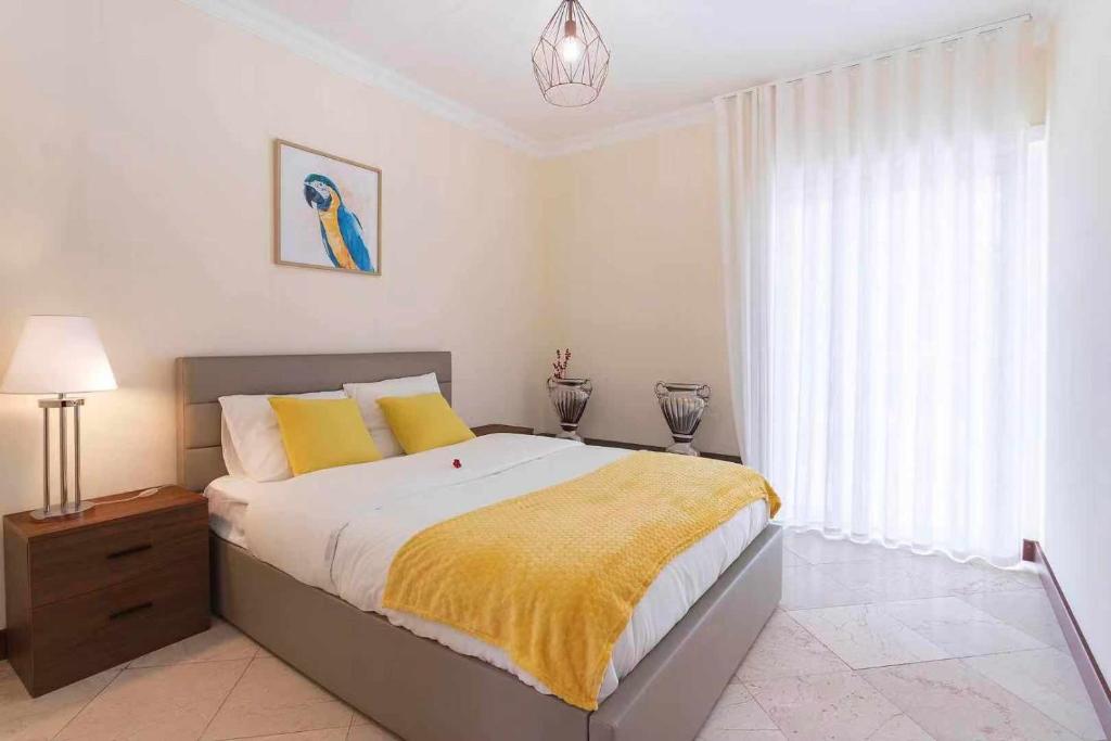 埃斯托利尔Heart of Ocean Dulpex Estoril的一间卧室配有一张带黄色毯子的大床