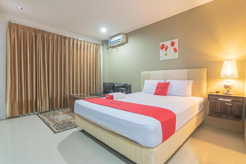 Sepinggang-KecilRedDoorz Plus near Sepinggan Airport 3 Balikpapan的一间卧室设有一张大床和一个窗户。