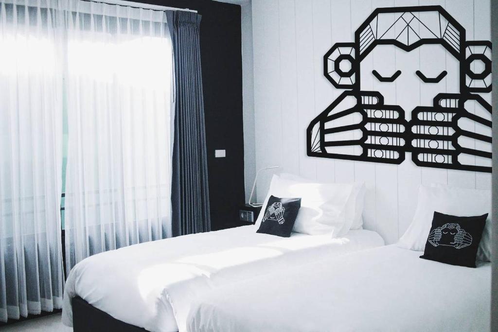 皮皮岛Blu Monkey Phi Phi Island的卧室配有两张床,墙上有标志