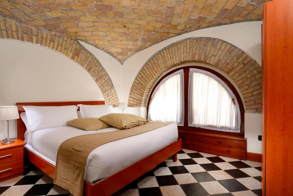 罗马特米尼罗马酒店的一间卧室配有一张砖墙床