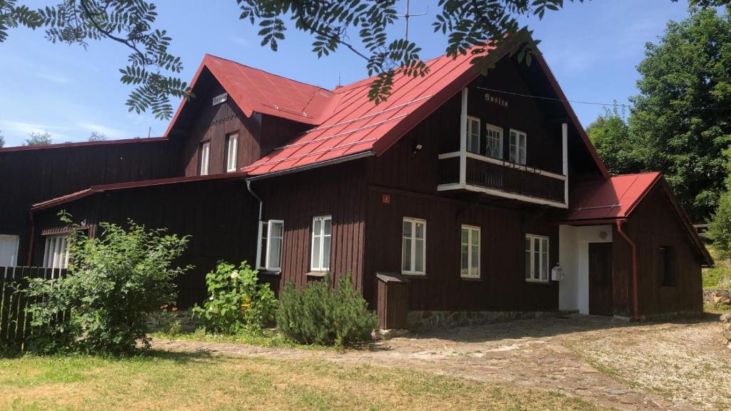 泽勒兹纳·鲁达Belvederská chalupa的黑色谷仓,有红色屋顶