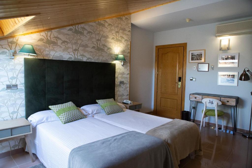 阿维拉莫拉达斯酒店的一间卧室配有一张白色大床和绿色床头板