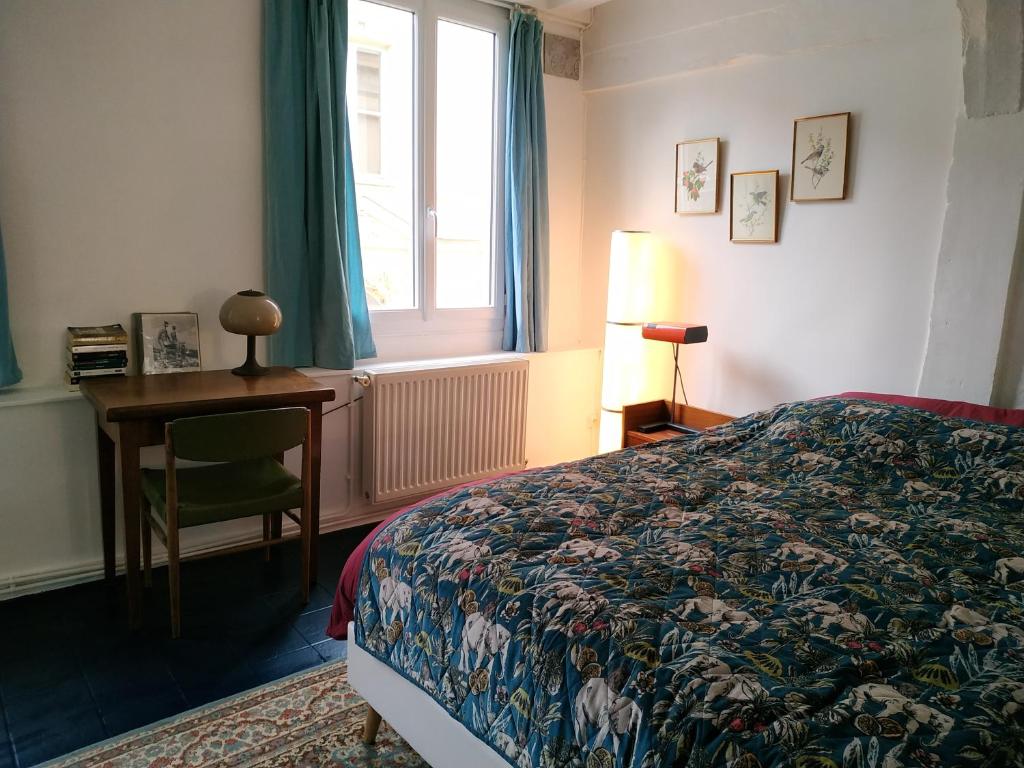 鲁昂Maison hypercentre Rouen tout confort的一间卧室配有一张床、一张书桌和一个窗户。