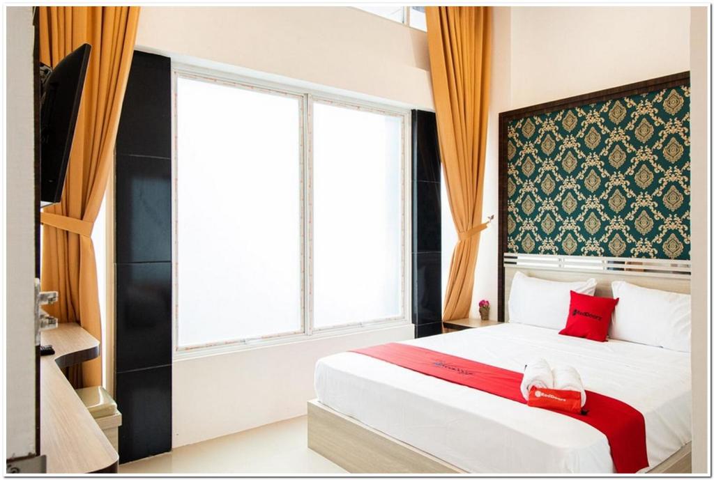 棉兰RedDoorz Plus @ Centrium Katamso Medan的一间卧室设有一张床和一个大窗户