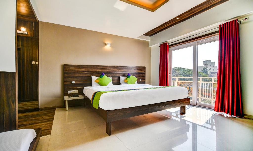 戈尔哈布尔Treebo Trend Shree Sai Suites的一间卧室设有一张床和一个大窗户