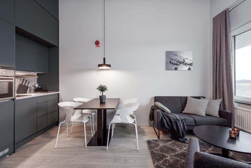 阿兰达Forenom Hotel Arlanda的厨房以及带桌子和沙发的客厅。