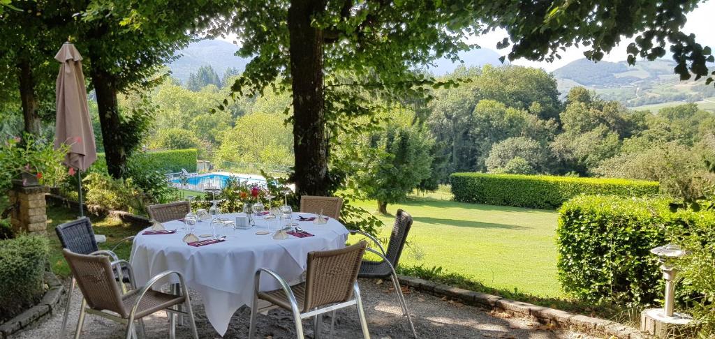 Saint-Martin-dʼUriage梅桑酒店的花园内一张带白色桌布和椅子的桌子
