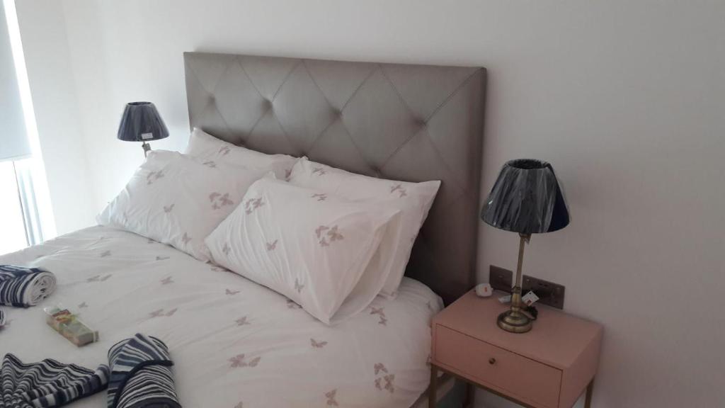 直布罗陀Ocean Village apartment的一间卧室配有一张带床头板的床和两盏灯。