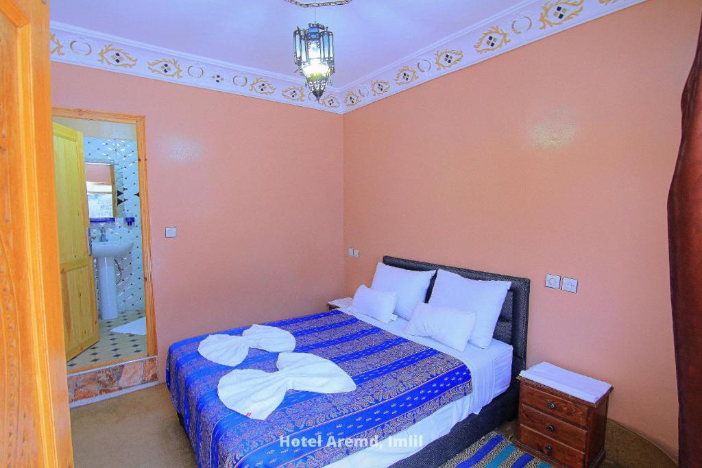 伊姆利尔Hotel Aremd - Aroumd Imlil route du Toubkal的一间小卧室,配有一张床和镜子