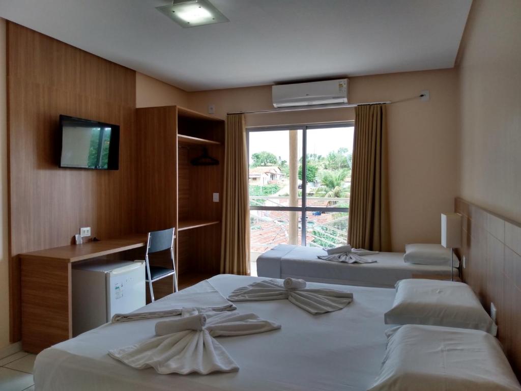 Colinas Do SulPlaneta Hotel的酒店客房设有两张床和窗户。