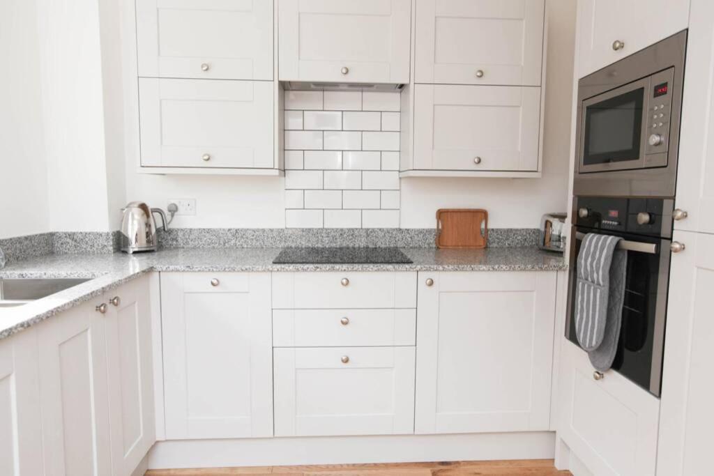 BlidworthRaynolds Cottage Blidworth的白色的厨房配有白色橱柜和电器