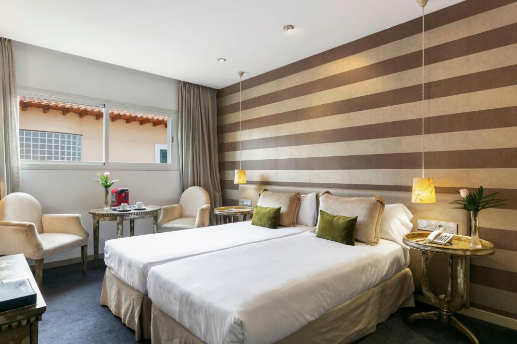 马德里全球亚西斯加勒蒂亚旅馆的酒店客房带一张大床和椅子
