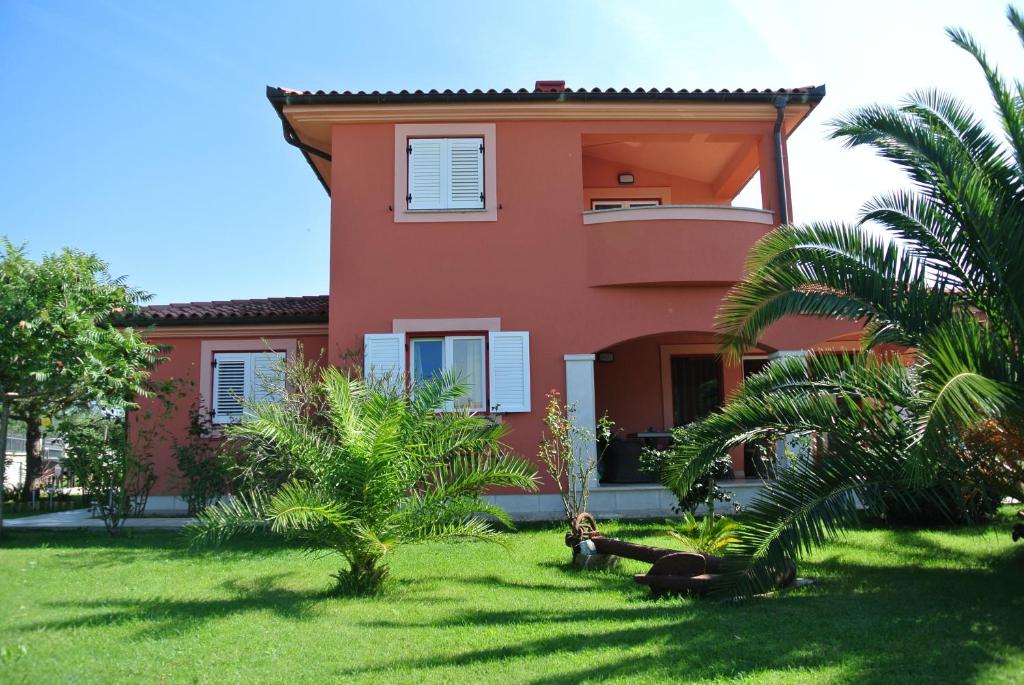 梅杜林VILLA ANCORA MEDULIN的一座棕榈树的红色房子