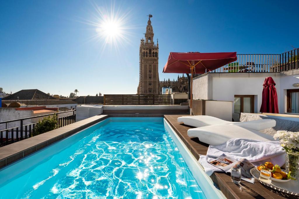 塞维利亚Cathedral Apartment, upper floor apartment的一座带钟楼建筑屋顶上的游泳池