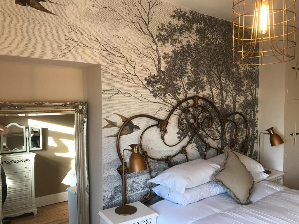 格兰奇奥沃桑茨Inglenook Cottage的一间卧室配有一张壁画床