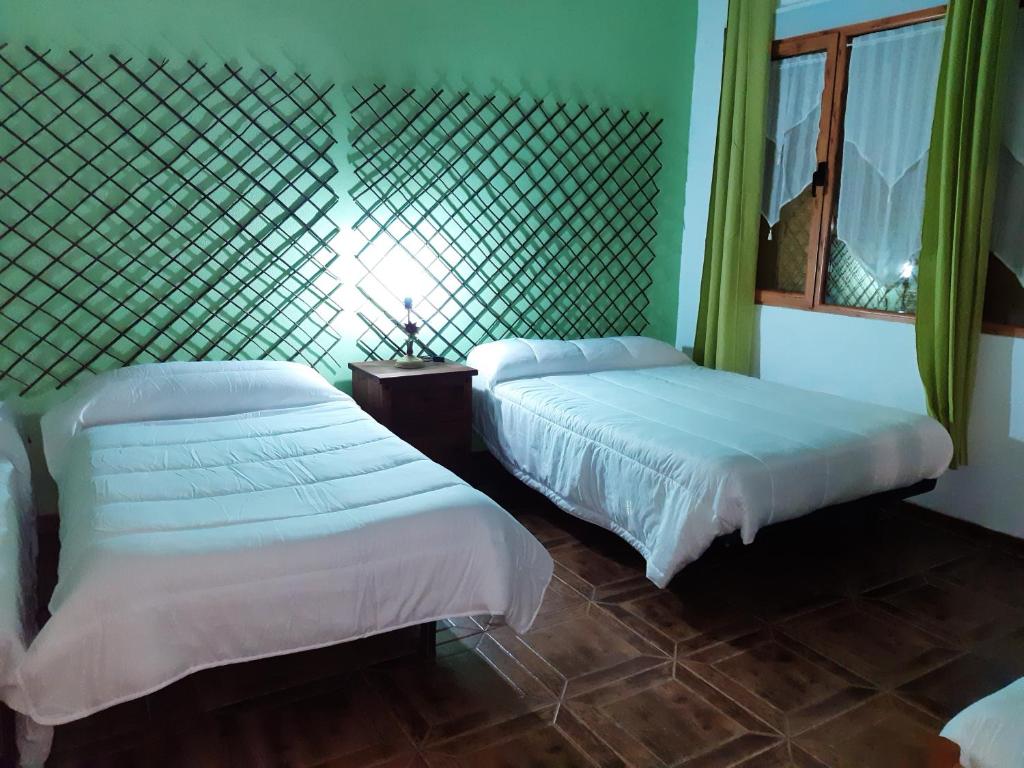 雷阿尔城Hostal Cabañeros的一间卧室配有两张床和镜子