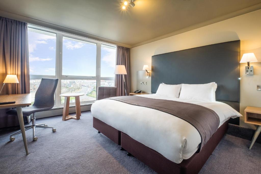 南安普敦南安普敦假日酒店的酒店客房设有一张床、一张书桌和窗户。