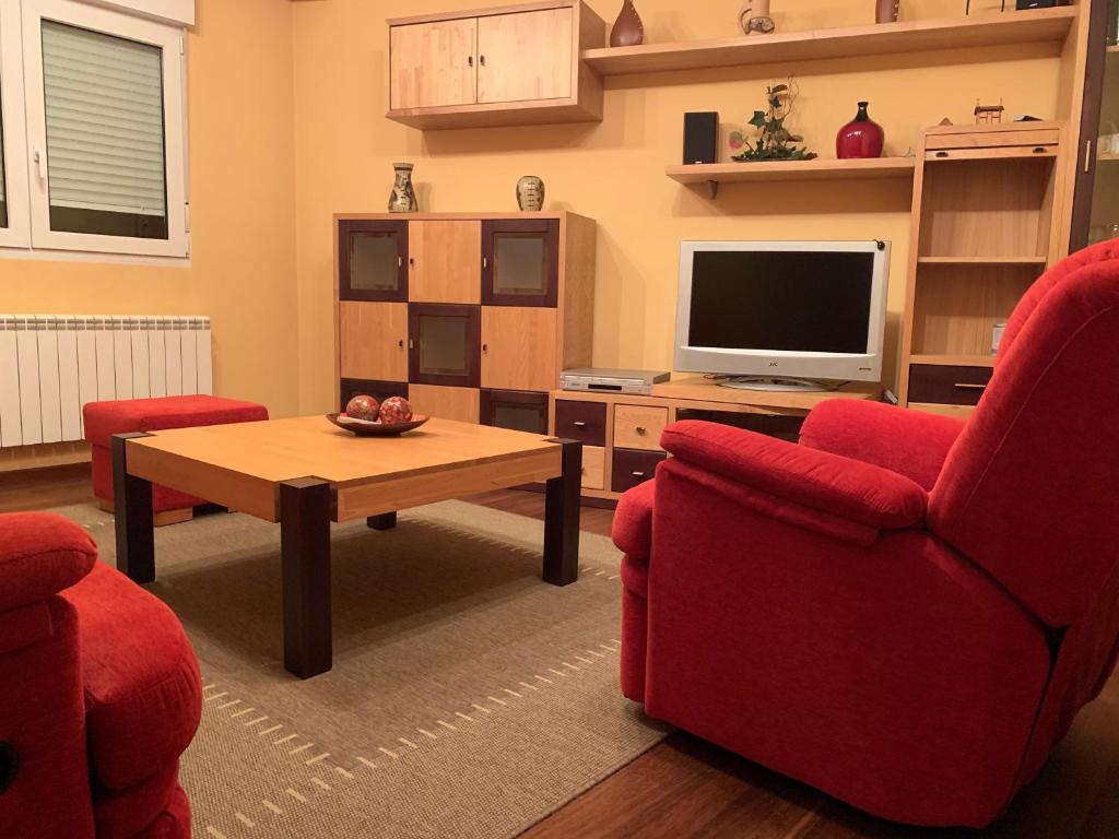 萨里亚Oktheway San Eufrasio的客厅配有2把红色椅子和电视