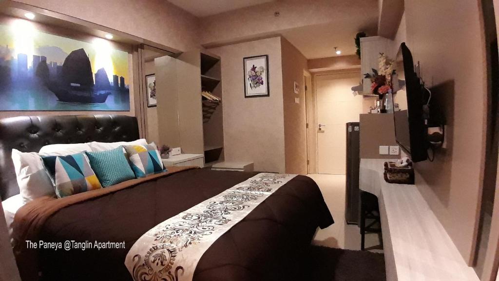 泗水The Paneya @Tanglin Apartment的一间卧室配有一张大床和一台冰箱