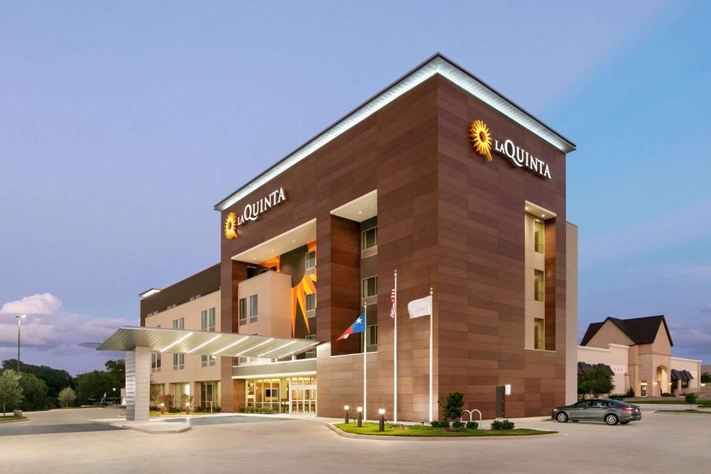 大学城La Quinta Inn & Suites by Wyndham College Station North的停车场内有停车位的建筑物